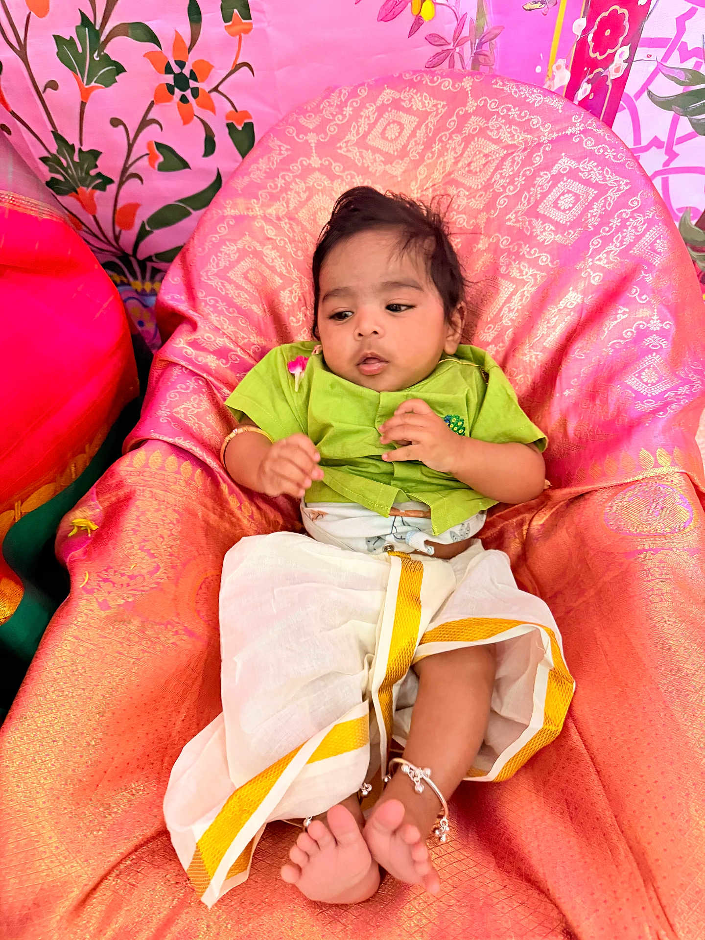 Srihan joined the competition — help win amazing prizes! baby, child, traditional_clothing, anklets, pink, orange, fabric, floral_pattern, indoor, portrait, cute, infant, colorful, person, seated, footwear, decor, small_child, happy, young