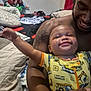 Ja'Leir is registered to the contest to win money with this photo: baby, adult, smile, tattoo, onesie, bedroom, pillow, blanket, clothing, person, happy, arm, holding, indoor, furniture, bed, fabric, child, family, casual