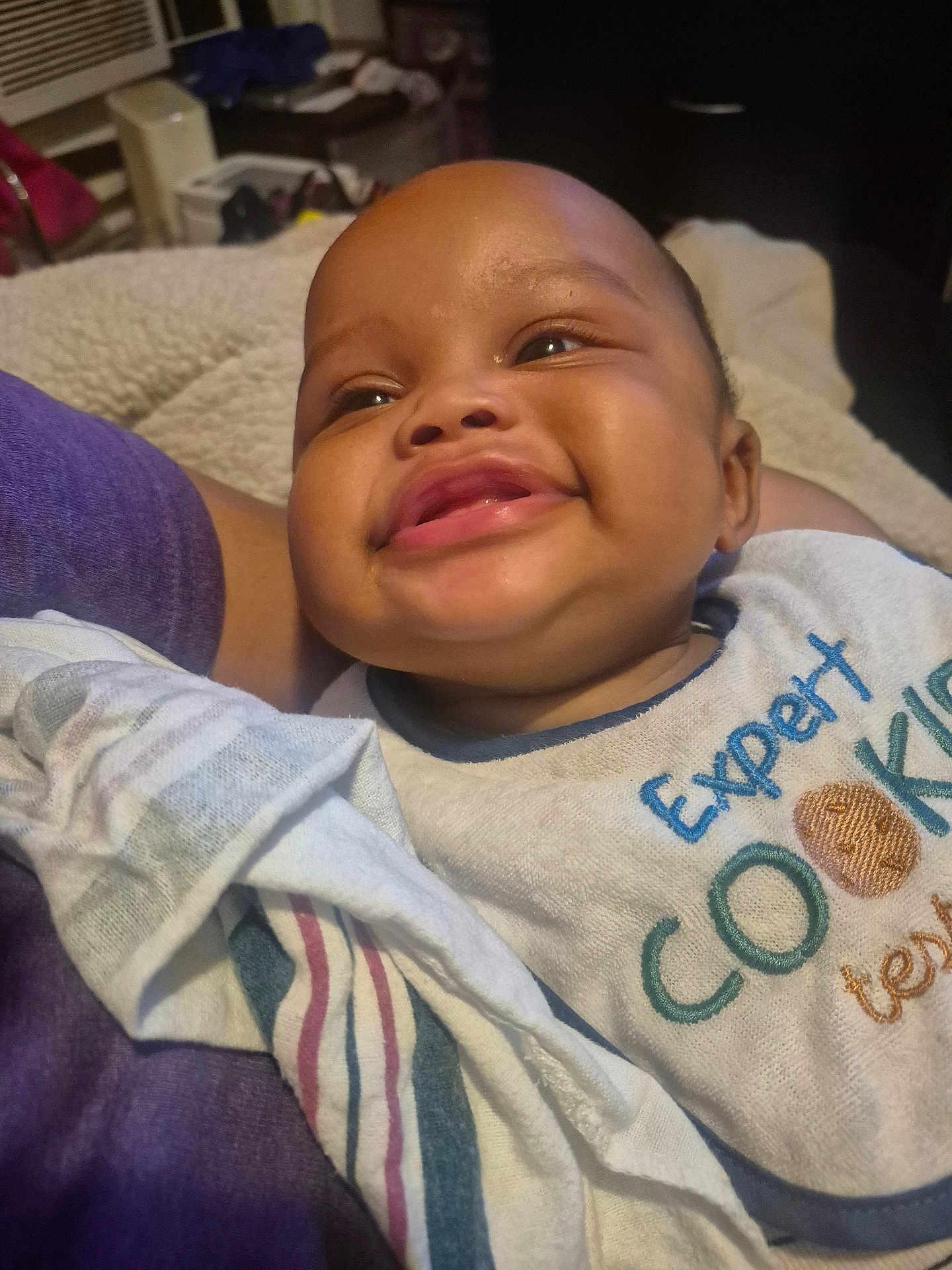 Ja'Leir joined the competition — help win amazing prizes! baby, smiling, bib, face, child, happy, indoor, person, clothing, text, fabric, closeup, skin, cute, infant, head, comfort, cozy, blanket, portrait