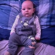 Noah joined the competition — help win amazing prizes! baby, infant, child, bed, blanket, bedding, clothing, mickey_mouse, gray_outfit, sitting, portrait, cute, indoors, soft_lighting, person, young_child, expression, face, footwear, sleepwear