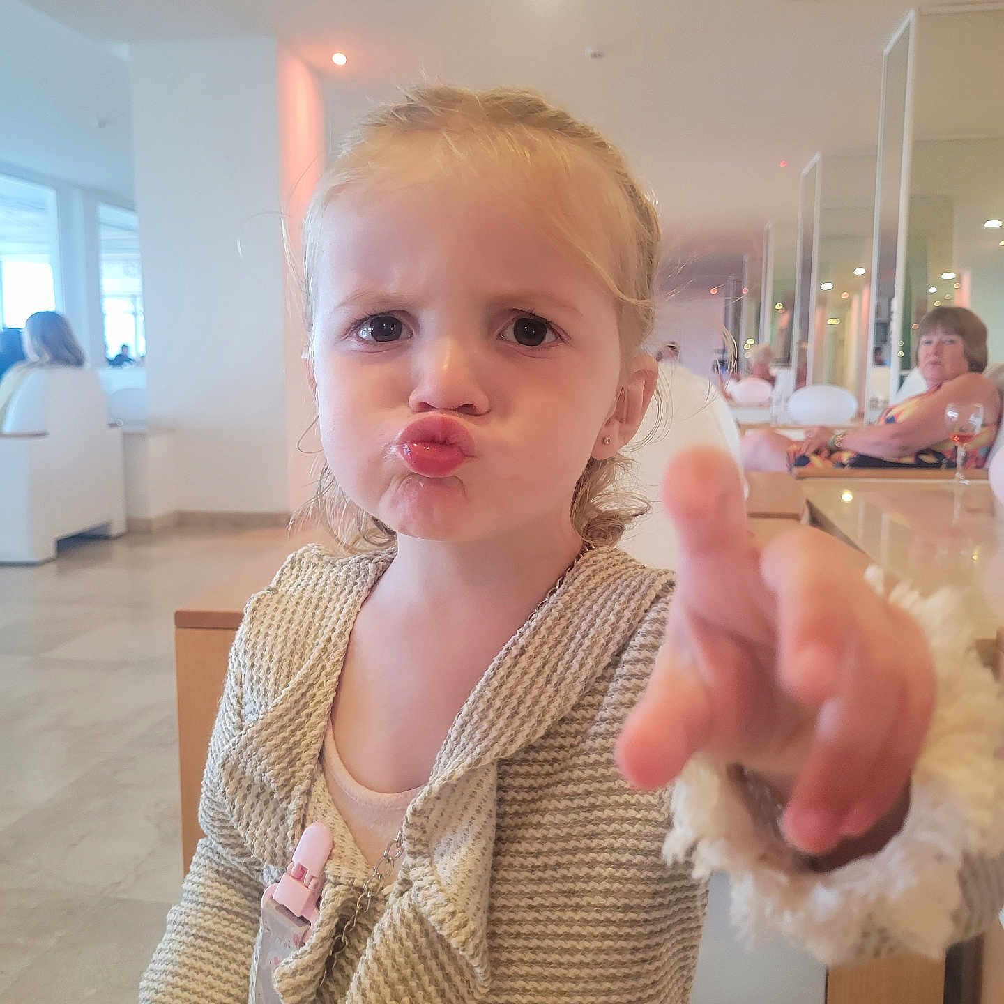 Lyria-Rose is registered to the contest to win money with this photo: background, casual, child, clothing, curly_hair, cute, expression, face, furniture, girl, indoor, light, modern, people, person, pointing, portrait, pout, room, woman