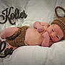 newborn, baby, infant, knitted_clothing, bunny_ears, blanket, white_background, wooden_sign, name_sign, lying_down, cute, soft_texture, sleepy, hand, foot, hospital_bracelet, portrait, cozy, child, resting