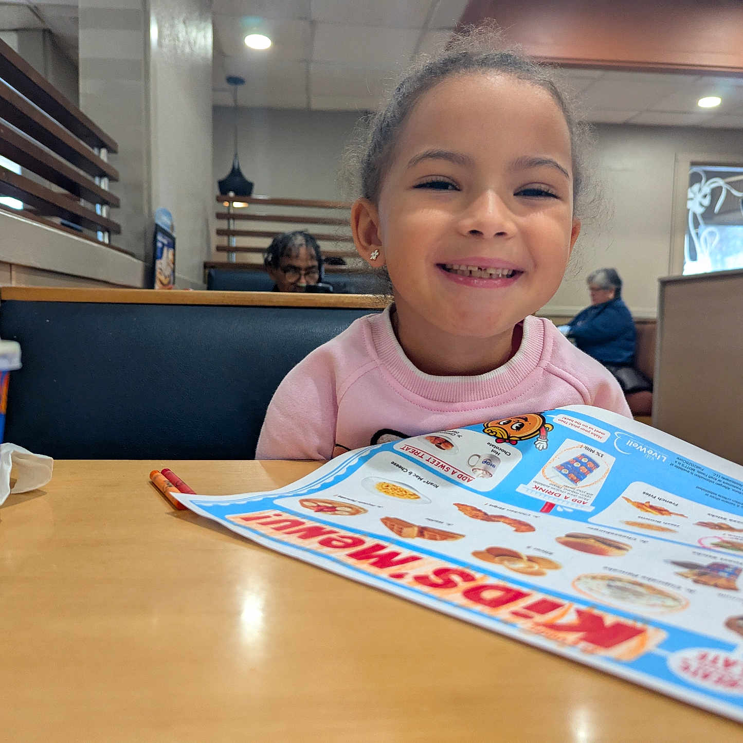 Naima is registered to the contest to win money with this photo: booth, casual, child, clothing, cup, dining, drink, family, food, girl, happy, indoor, menu, menu_board, person, portrait, restaurant, seat, smiling, table
