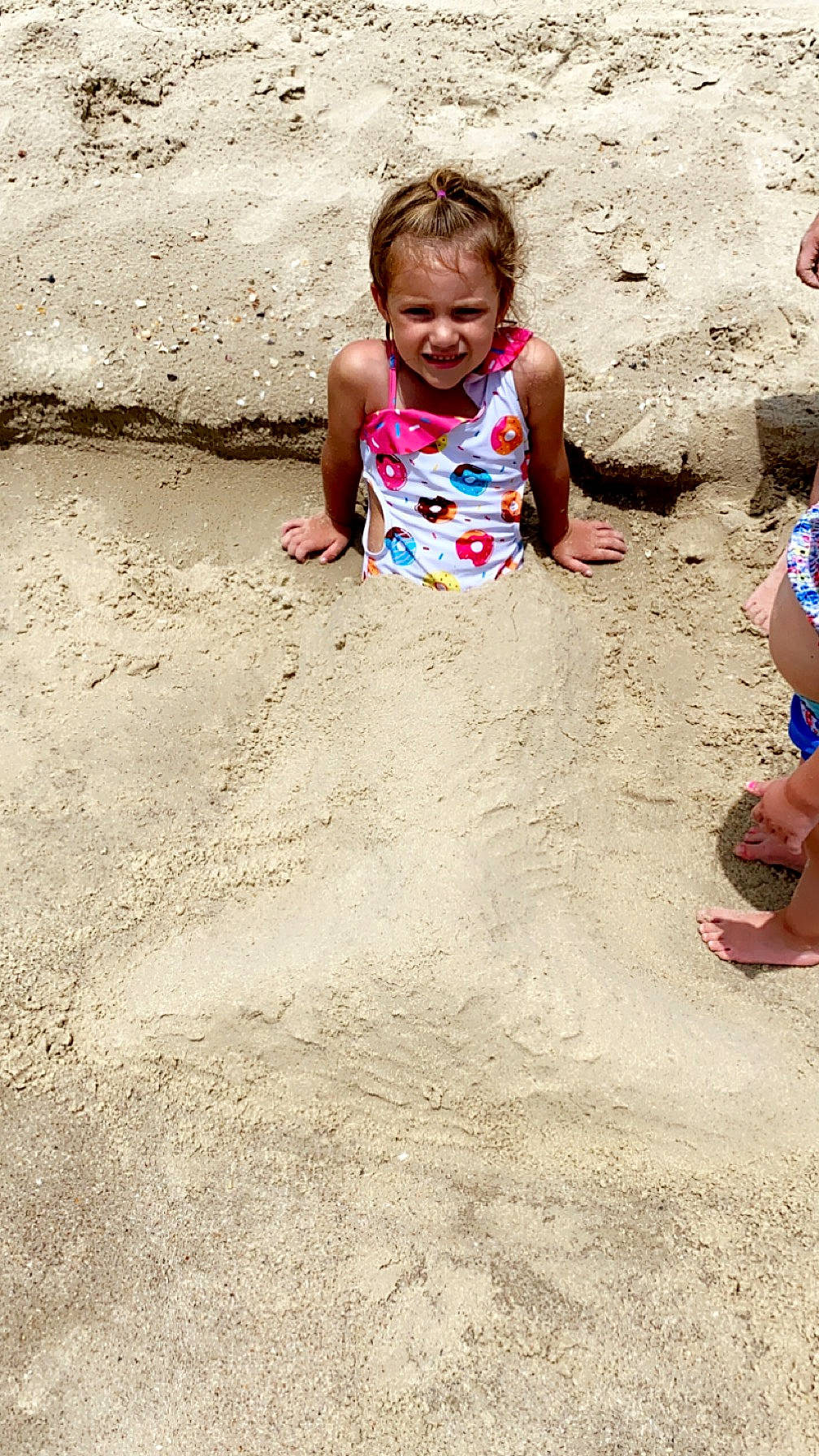 Ava is registered to the contest to win money with this photo: beach, eye, facial_expression, foot, fun, hairstyle, happy, joy, leg, leisure, mouth, people_in_nature, people_on_beach, person, play, recreation, sand, sitting, smile, soil