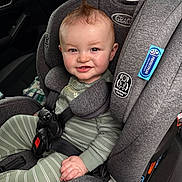 Josiah is registered to the contest to win money with this photo: baby, child, car_seat, gray, smile, mohawk, hair, seatbelt, infant, clothing, striped_pajamas, car_interior, window, door, safety, happy, cute, young, person, seat