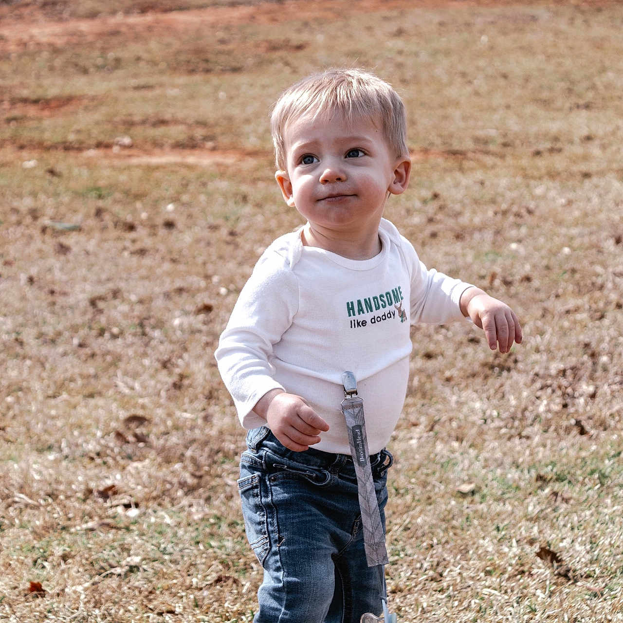 Hudson is registered to the contest to win money with this photo: bodypart, boy, child, clothing, face, finger, grass, happy, head, jeans, male, pants, person, photography, plant, portrait, shirt, smile, soil, t_shirt