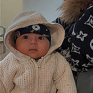 Hatem participe au concours pour gagner de l'argent avec cette photo : baby, child, hoodie, knitted, headband, person, clothing, indoor, portrait, cute, warm, holding, face, expression, fashion, jacket, pattern, hand, young, cozy
