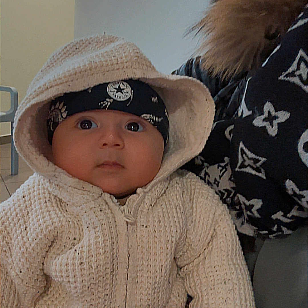 Hatem participe au concours pour gagner de l'argent avec cette photo : baby, child, clothing, cozy, cute, expression, face, fashion, hand, headband, holding, hoodie, indoor, jacket, knitted, pattern, person, portrait, warm, young