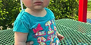 Kaylee Ryan joined the competition — help win amazing prizes! baby, blue_shirt, casual_clothing, child, daylight, expression, furniture, greenery, hand, hat, nature, outdoor, person, picnic_table, playground, shorts, sitting, skin, summer, sunhat