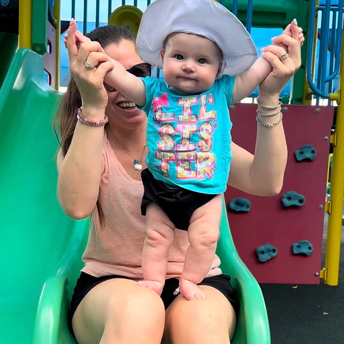 Kaylee Ryan joined the competition — help win amazing prizes! baby, child, clothing, family, fun, happy, hat, holding_hands, legs, outdoor, park, play, playground, slide, smile, summer, sunglasses, toy, tshirt, woman