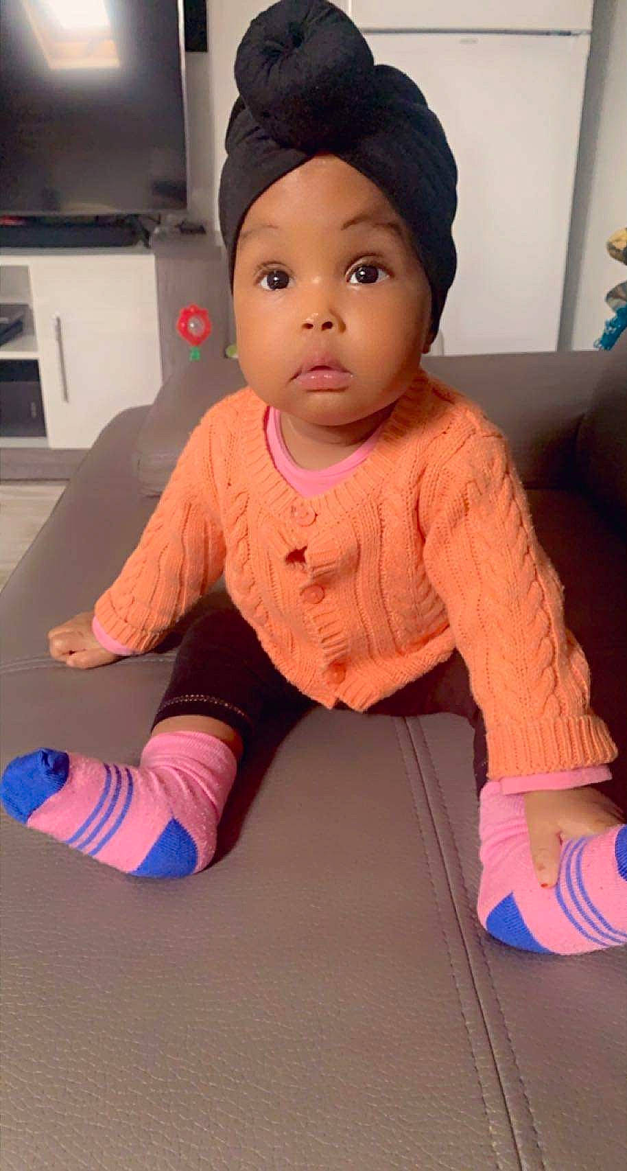 Fatoumata a rejoint le concours — aidez-le/la à gagner de superbes lots ! baby_toddler_clothing, cap, cheek, child, eye, floor, flooring, fun, headgear, home_appliance, human_body, joint, lip, neck, nose, person, pink, skin, sleeve, surprise