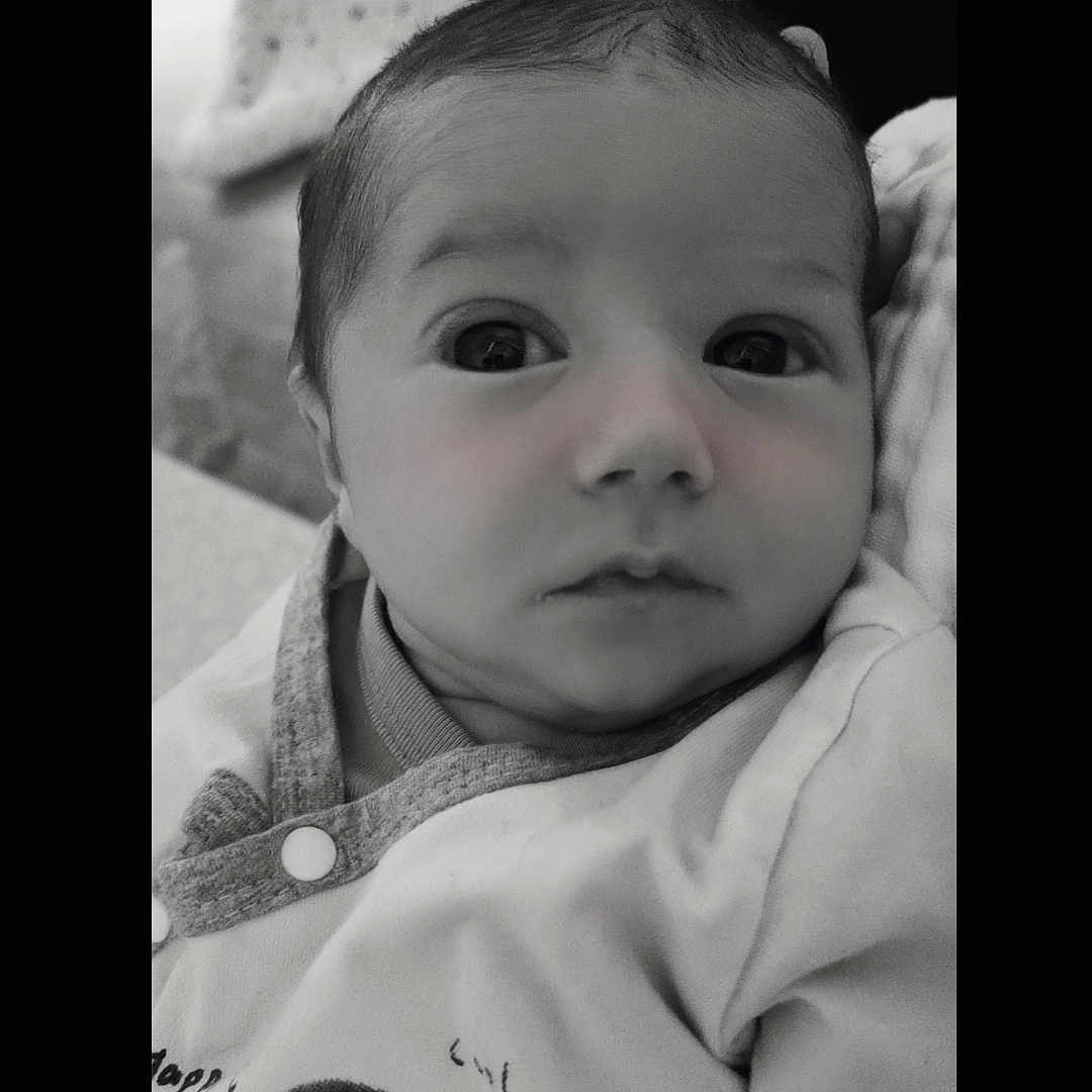 Taylor participe au concours pour gagner de l'argent avec cette photo : baby, baby_garment, black_and_white, child, close_up, clothing, cute, eyes, face, head, indoors, infant, newborn, onesie, person, portrait, skin, sleeping_area, soft_texture, teddy_bear