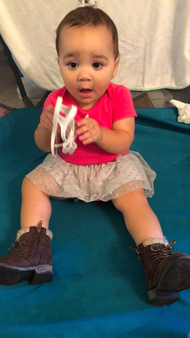 Leighton is registered to the contest to win money with this photo: arm, baby, cheek, child, footwear, head, leg, person, play, shoe, sitting, skin, smile, surprise, toddler, vacation