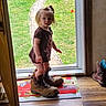 Lilly joined the competition — help win amazing prizes! child, toddler, girl, blonde_hair, ponytail, face, standing, outdoor, doorway, backyard, grass, pathway, boots, oversized_shoes, clothing, dress, toy, doormat, wooden_floor, portrait