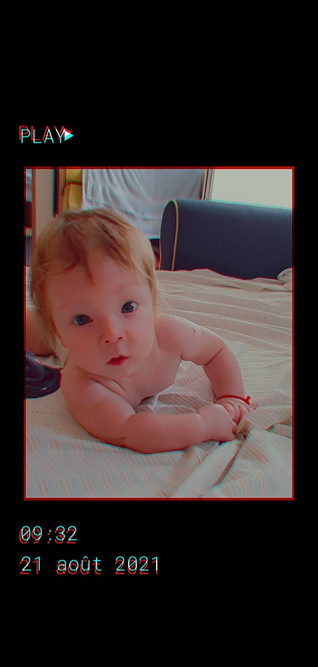 Iulian participe au concours pour gagner de l'argent avec cette photo : baby, baby_products, baby_toddler_clothing, cheek, child, comfort, display_device, electronic_device, eyelash, font, gadget, hairstyle, happy, linens, person, photo_caption, portrait_photography, rectangle, room, surprise