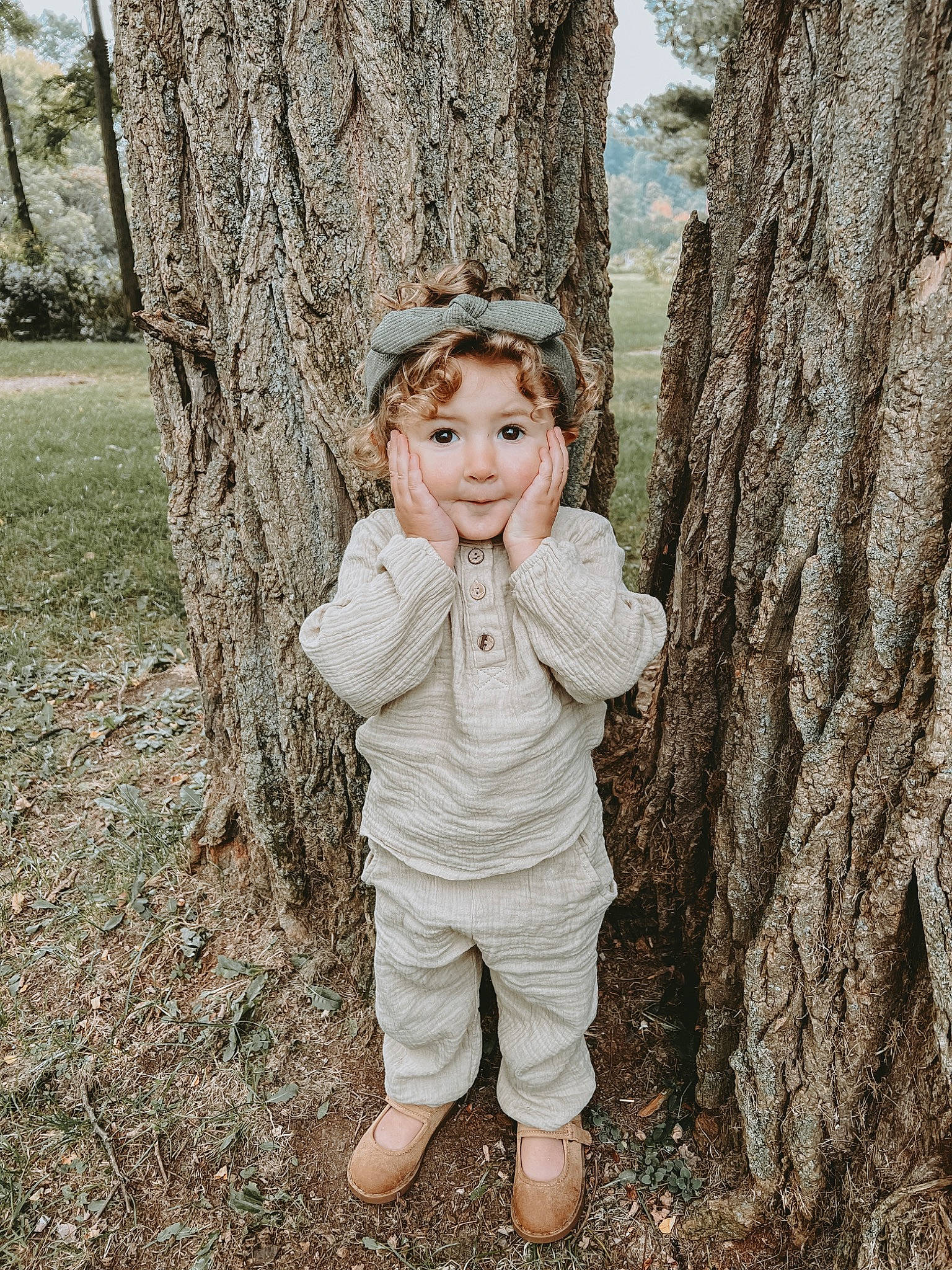 Ana joined the competition — help win amazing prizes! botany, branch, face, forest, gesture, grass, happy, human_body, people_in_nature, person, plant, smile, standing, toddler, tree, trunk, twig, wood, woodland, woody_plant