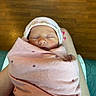 newborn, baby, infant, wrapped, blanket, pink, hat, teddy_bear, sleeping, face, person, lap, skin, nail_polish, wood_floor, indoor, cozy, cute, peaceful, resting