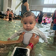 Sahara joined the competition — help win amazing prizes! baby, child, swimming_pool, water, indoor, people, adult, person, holding, swimwear, wet_hair, water_activity, family, recreation, poolside, fun, crowd, leisure, casual, parent