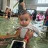 baby, child, swimming_pool, water, indoor, people, adult, person, holding, swimwear, wet_hair, water_activity, family, recreation, poolside, fun, crowd, leisure, casual, parent