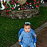 toddler, child, blue_bow, denim_outfit, sneakers, small_chair, flower_bed, colorful_flowers, green_grass, stone_border, garden, outdoor, decorative_swan, pathway, sidewalk, plant, tree, cute, portrait, happy