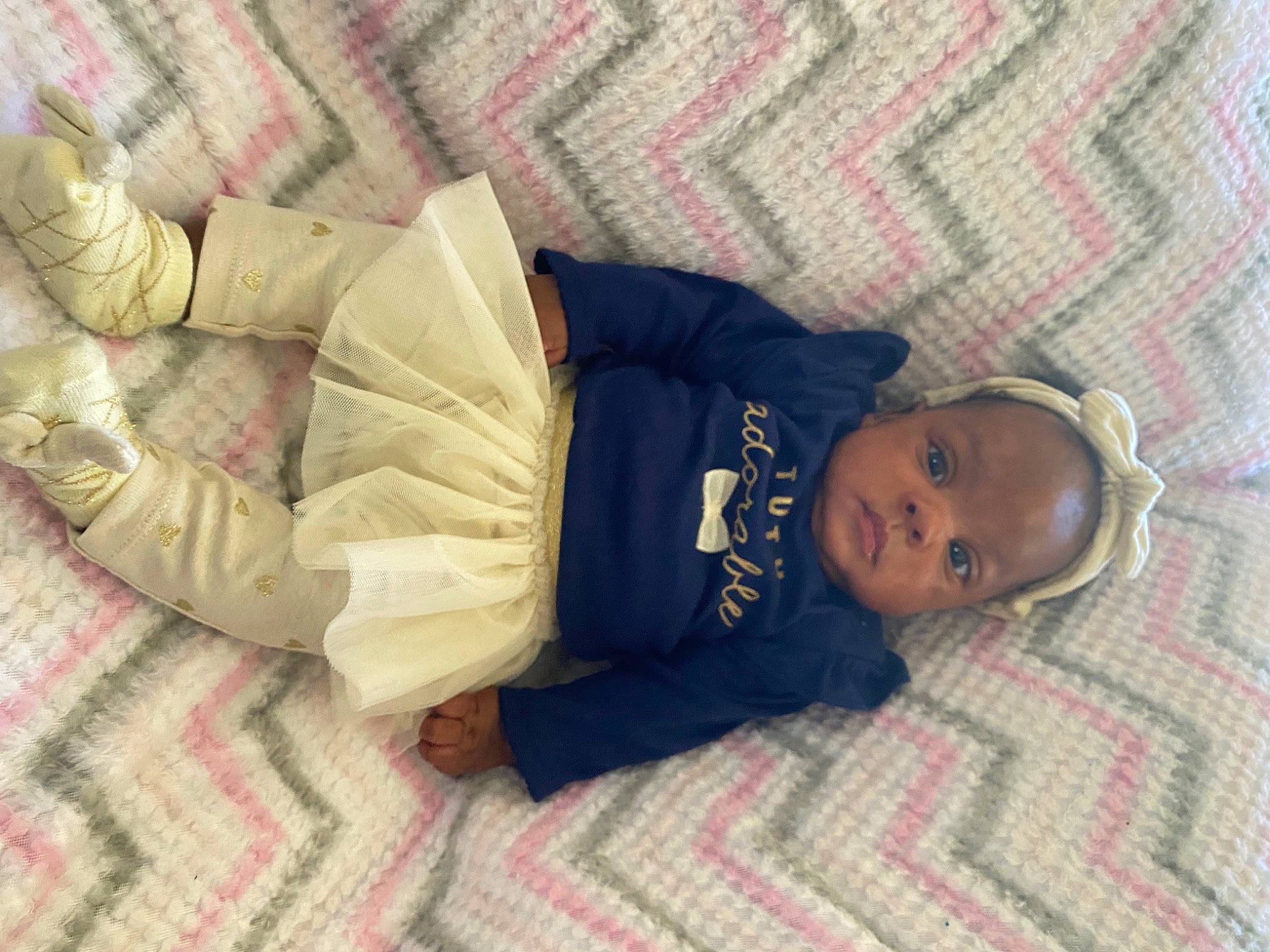 Kennedy is registered to the contest to win money with this photo: baby, baby_toddler_clothing, bedding, bedtime, child, comfort, eye, face, floor, flooring, head, human_leg, linens, pattern, person, skin, sleeve, textile, thigh, toddler