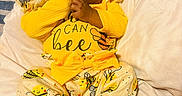 Abbiegale joined the competition — help win amazing prizes! baby, infant, child, yellow_clothing, headband, cute, lying_down, blanket, soft_texture, indoors, cozy, hand_on_mouth, bright_colors, bee_pattern, foot, sleepwear, portrait, young_child, comfortable, closeup