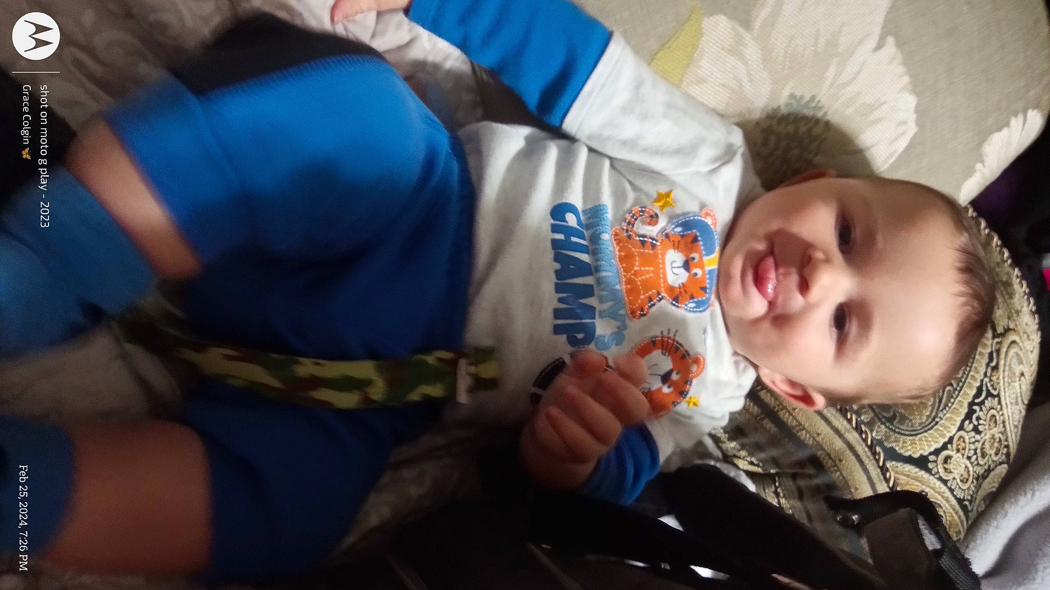 Zayne is registered to the contest to win money with this photo: baby, baby_products, baby_toddler_clothing, cheek, child, comfort, electric_blue, fun, gesture, happy, person, room, sitting, skin, sleeve, smile, thumb, toddler, tree