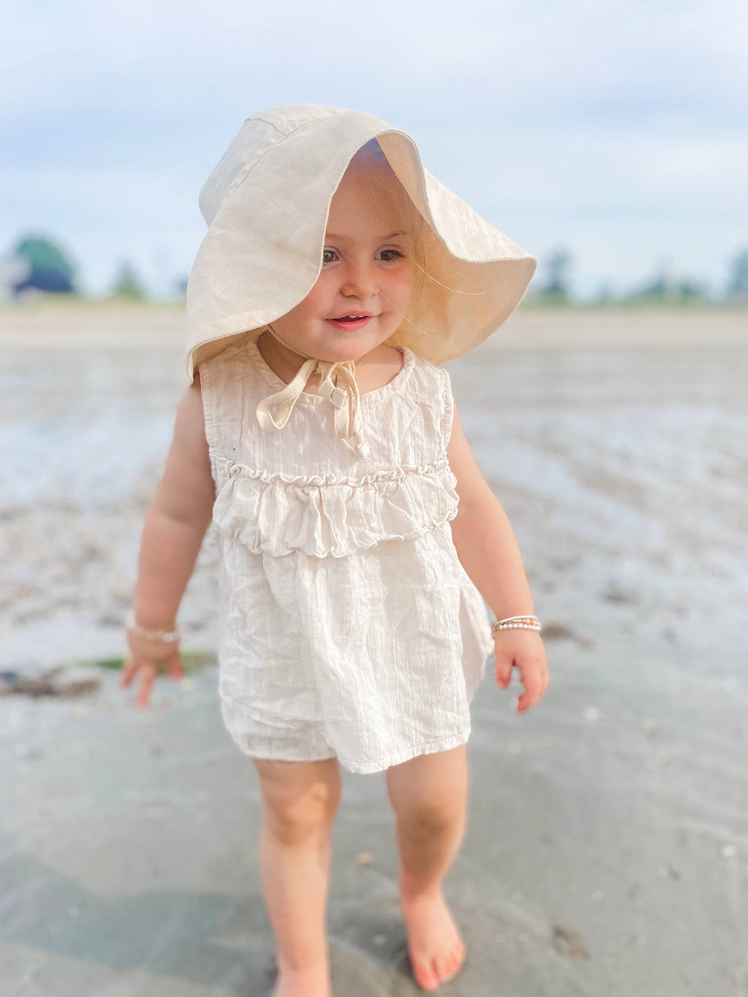 Thea is registered to the contest to win money with this photo: barefoot, beach, blond, body_of_water, dress, fun, happy, head, headgear, headwear, human_body, human_leg, joy, people_in_nature, person, recreation, sand, skin, sky, sleeve