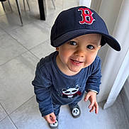 Kaden a rejoint le concours — aidez-le/la à gagner de superbes lots ! toddler, child, hat, cap, smile, floor, tile, indoor, clothing, panda, blue_shirt, shoes, curtain, person, cute, happy, standing, looking_up, baby, portrait