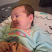 Madilynn is registered to the contest to win money with this photo: baby, infant, blanket, clothing, face, head, person, portrait, hand, sleeve, cushion, pattern, fabric, indoor, soft, resting, cute, young_child, lying_down, cozy