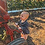John joined the competition — help win amazing prizes! toddler, child, outdoor, sunflower, field, farm, tractor_part, soil, sunlight, blue_outfit, wheel, smiling, baby, nature, daylight, agriculture, greenery, rustic, playful, young_child