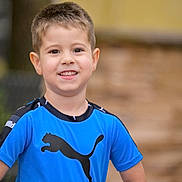 Carlos López joined the competition — help win amazing prizes! child, boy, smile, portrait, blue_shirt, puma_logo, short_hair, teeth, ears, eyes, skin, happy, outdoor, blurred_background, bokeh, sportswear, standing, casual_clothing, person, youth