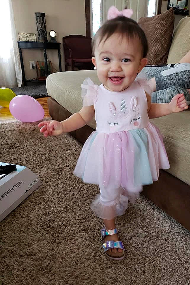Ariah is registered to the contest to win money with this photo: baby, baby_toddler_clothing, beauty, cheek, child, dress, electronic_device, floor, head, joy, person, pink, play, room, sitting, skin, smile, standing, toddler
