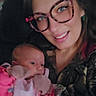 baby, woman, glasses, blanket, indoor, portrait, smile, face, person, holding, pink, curious, casual, cozy, family, young_child, eyewear, apparel, blanket_pattern, home