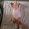 baby, infant, blanket, pink_clothing, headband, bow, smile, shoes, sparkly, pattern, carpet, floor, cute, happy, lying_down, child, indoors, toddler, person, apparel