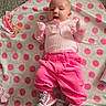 𝕃𝕠𝕣𝕖𝕟𝕖 is registered to the contest to win money with this photo: baby, infant, pink_clothing, shoes, blanket, polka_dots, carpet, floor, cute, lying_down, child, indoors, apparel, footwear, small_person, happy, face, head, hands, casual
