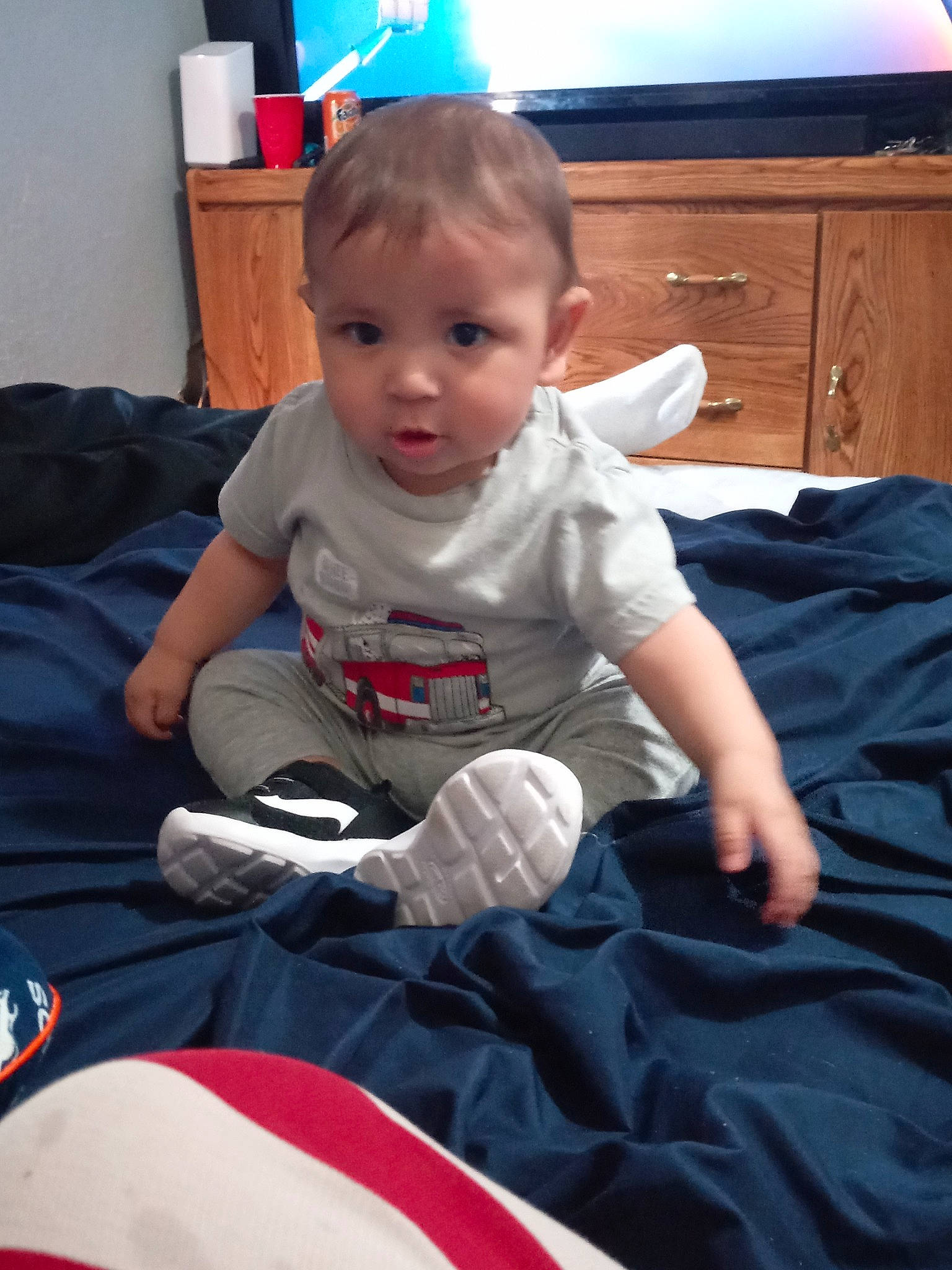 Brandon is registered to the contest to win money with this photo: arm, baby, baby_toddler_clothing, blue, cabinetry, cheek, chest_of_drawers, child, comfort, drawer, facial_expression, finger, fun, lap, mammal, person, sleeve, standing, t_shirt, toddler