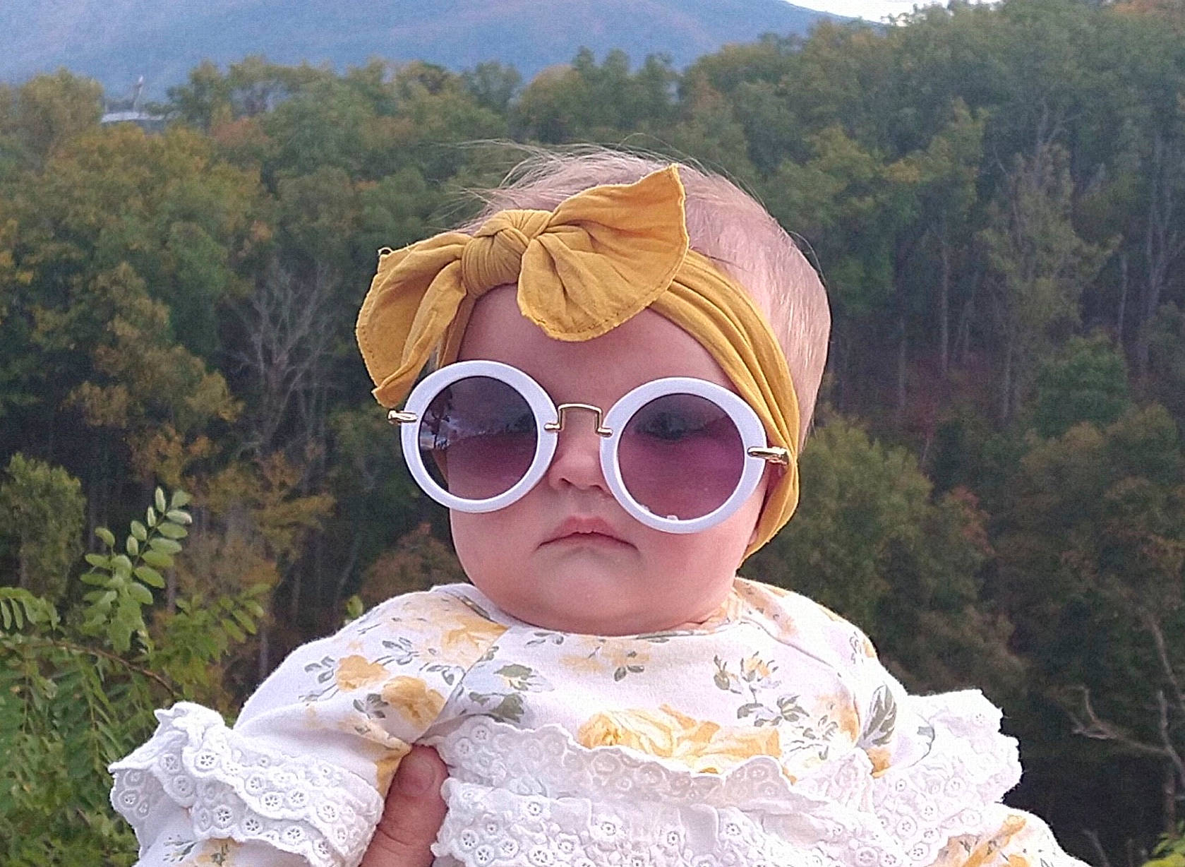 Bonnie is registered to the contest to win money with this photo: baby_toddler_clothing, cap, chin, eye, eyewear, face, glasses, goggles, grass, hairstyle, happy, head, headgear, human_body, lip, people_in_nature, person, sky, sunglasses, tree
