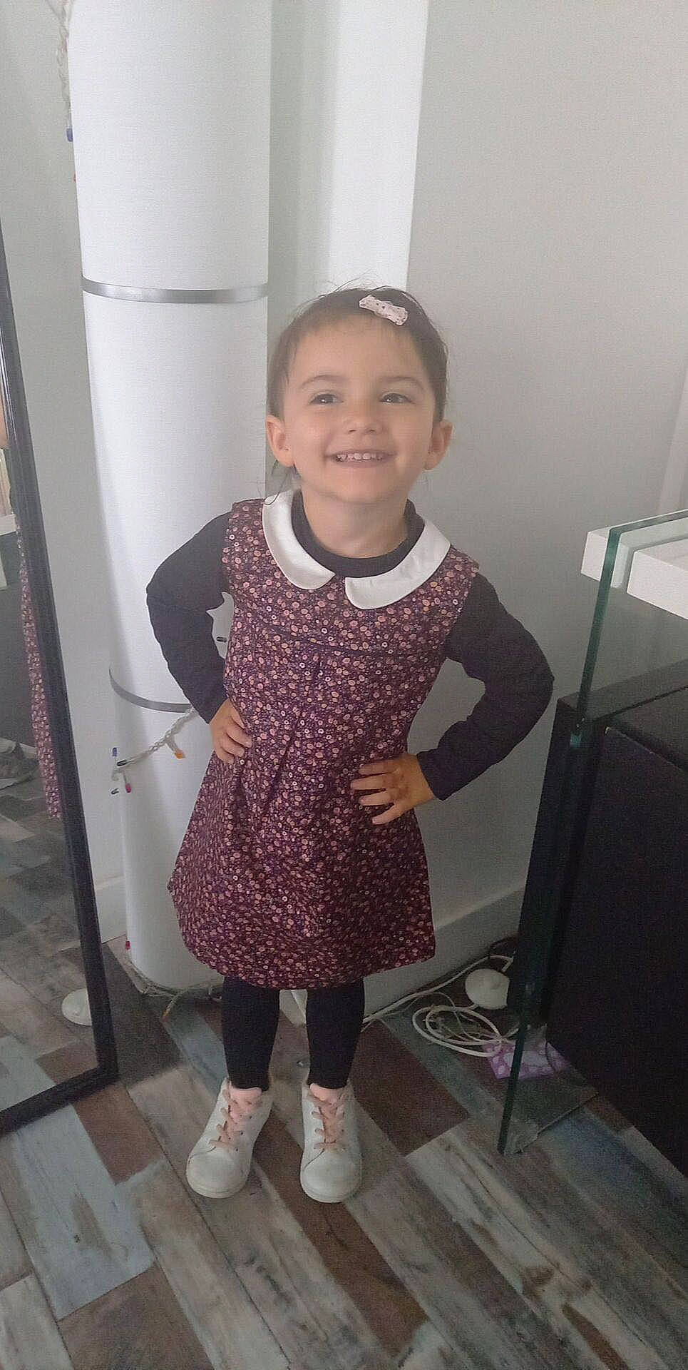 Maëlys participe au concours pour gagner de l'argent avec cette photo : baby_toddler_clothing, face, fashion_accessory, happy, human_body, human_leg, joy, knee, leg, leggings, magenta, pattern, person, purple, shoulder, sleeve, smile, sock, standing, thigh