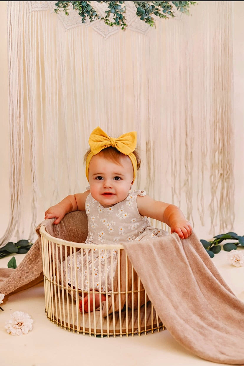 Kaisley is registered to the contest to win money with this photo: baby, baby_products, baby_safety, baby_toddler_clothing, child, dress, fashion_accessory, happy, headpiece, infant_bed, joy, pattern, peach, person, portrait_photography, room, sitting, sleeve, smile, sun_hat