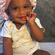 Nova is registered to the contest to win money with this photo: baby, child, smiling, sitting, bonnet, clothing, hand, face, cute, indoors, infant, portrait, happy, skin, headwear, furniture, blanket, cozy, person, toddler