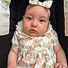 Evie joined the competition — help win amazing prizes! baby, bow, car_seat, child, closeup, clothing, comfort, cute, eyes, face, floral_dress, hand, headband, indoor, infant, person, portrait, safety, sitting, skin