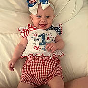 Tilly joined the competition — help win amazing prizes! baby, infant, smiling, red_white_blue, bow, headband, clothing, cute, celebration, holiday, lying_down, white_background, happy, cheerful, portrait, child, people, one_year_old, patterned_clothing, festive