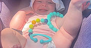 Tilly is registered to the contest to win money with this photo: baby, car_seat, purple, sun_hat, toy, beads, smiling, infant, cute, playful, child, seat, comfort, happy, legs, clothing, indoor, person, headwear, portrait