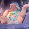 baby, car_seat, purple, sun_hat, toy, beads, smiling, infant, cute, playful, child, seat, comfort, happy, legs, clothing, indoor, person, headwear, portrait