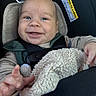 baby, child, car_seat, smiling, happy, blanket, seatbelt, infant, clothing, face, hand, indoor, cute, closeup, safe, person, toddler, comfort, young_child, car_interior