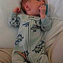 Atreus is registered to the contest to win money with this photo: baby, newborn, pacifier, onesie, dinosaur_pattern, infant, sleepwear, soft_fabric, couch, blanket, comfort, resting, cute, small_hands, face, head, lying_down, indoors, child, cozy