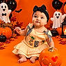 Daleyza Everly is registered to the contest to win money with this photo: baby, child, halloween, pumpkin, jack_o_lantern, costume, headband, bow, dress, sitting, smiling, portrait, indoor, decoration, balloons, ghost, bats, autumn_leaves, orange_background, candle