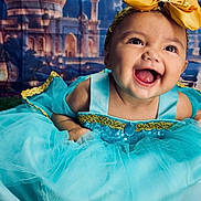 Daleyza Everly is registered to the contest to win money with this photo: baby, child, toddler, portrait, smiling, happy, laughing, face, eyes, open_mouth, dress, costume, turquoise, gold, bow, crown, sequins, indoor, palace, royal