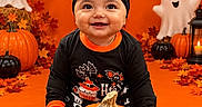 Daleyza Everly is registered to the contest to win money with this photo: baby, child, halloween, pumpkin, jack_o_lantern, costume, bow_headband, smiling, portrait, indoor, orange_background, ghost_decorations, bat_decorations, balloons, autumn_leaves, black_clothing, festive, seasonal, candle, studio_photography